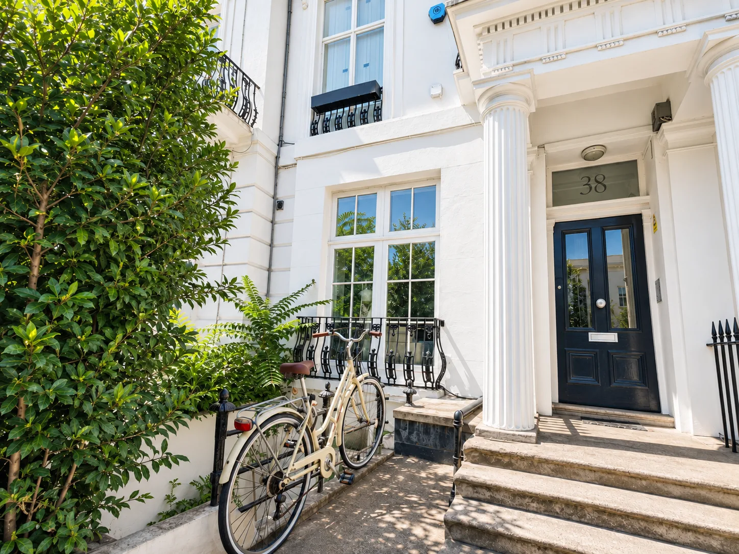 Bright white townhouse exterior on Pembridge Villas, W11